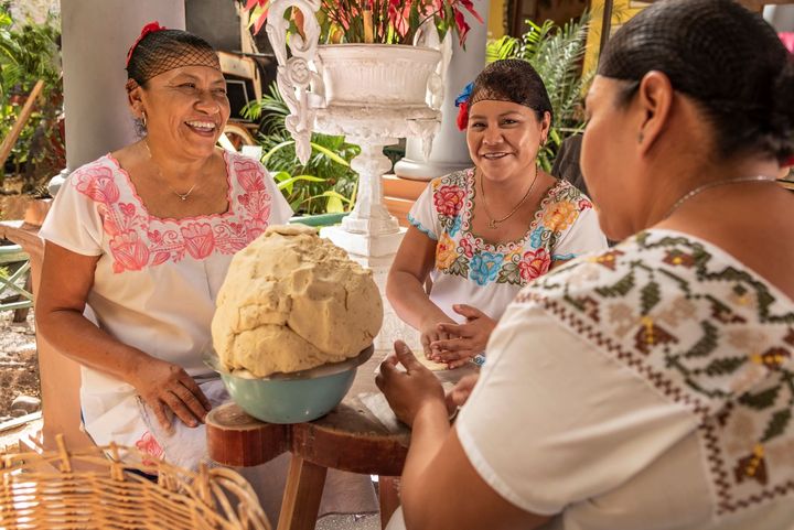 Group of smiling cooks preparing flat bread tortillas in Yucatan, Mexico